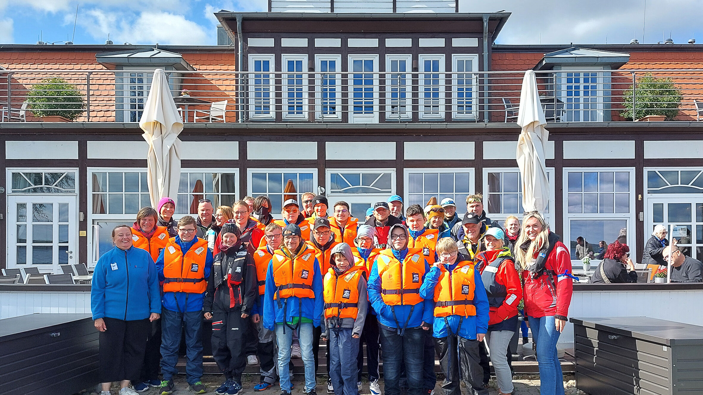 A group of children wearing life jackets in front of an old building
