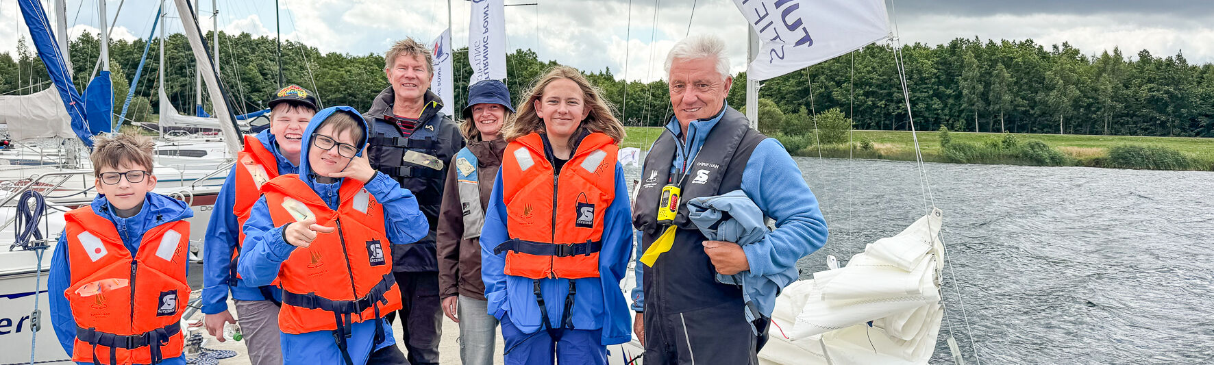 Eine Gruppe von Teilnehmenden und Trainern steht auf dem Steg. Daneben liegt eine Sonar im Wasser.