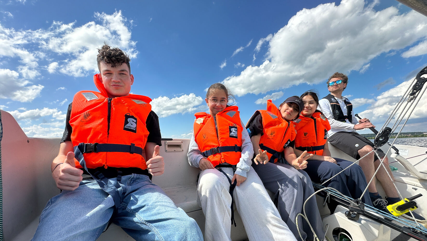 Teilnehmende sitzen in einer Sonar. Alle haben Rettungswesten an.