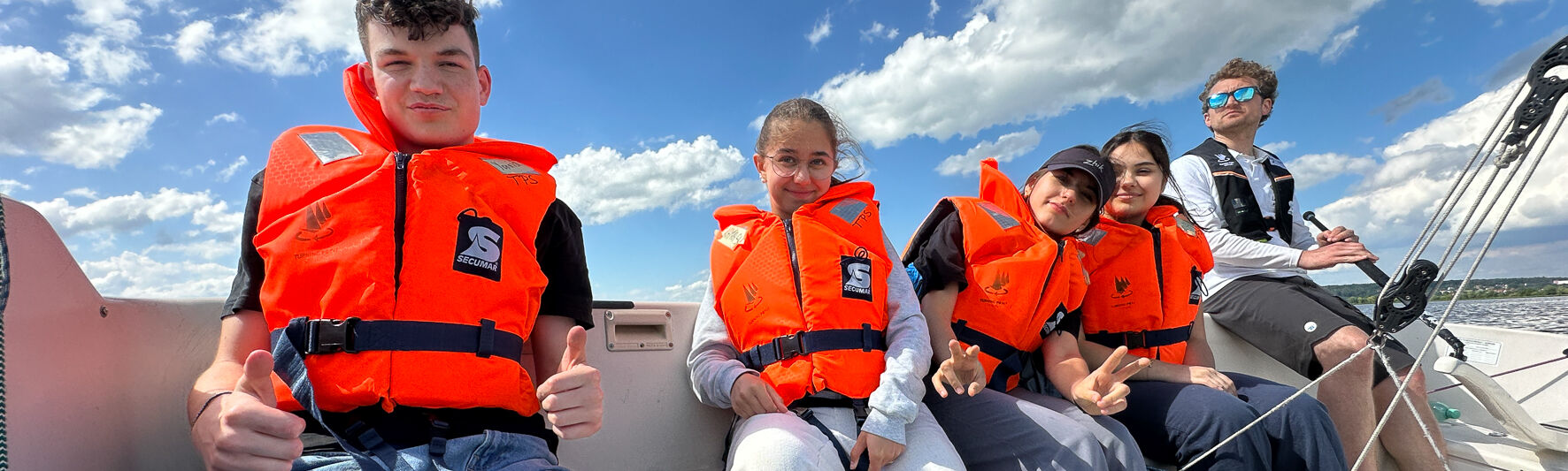 Teilnehmende sitzen in einer Sonar. Alle haben Rettungswesten an.